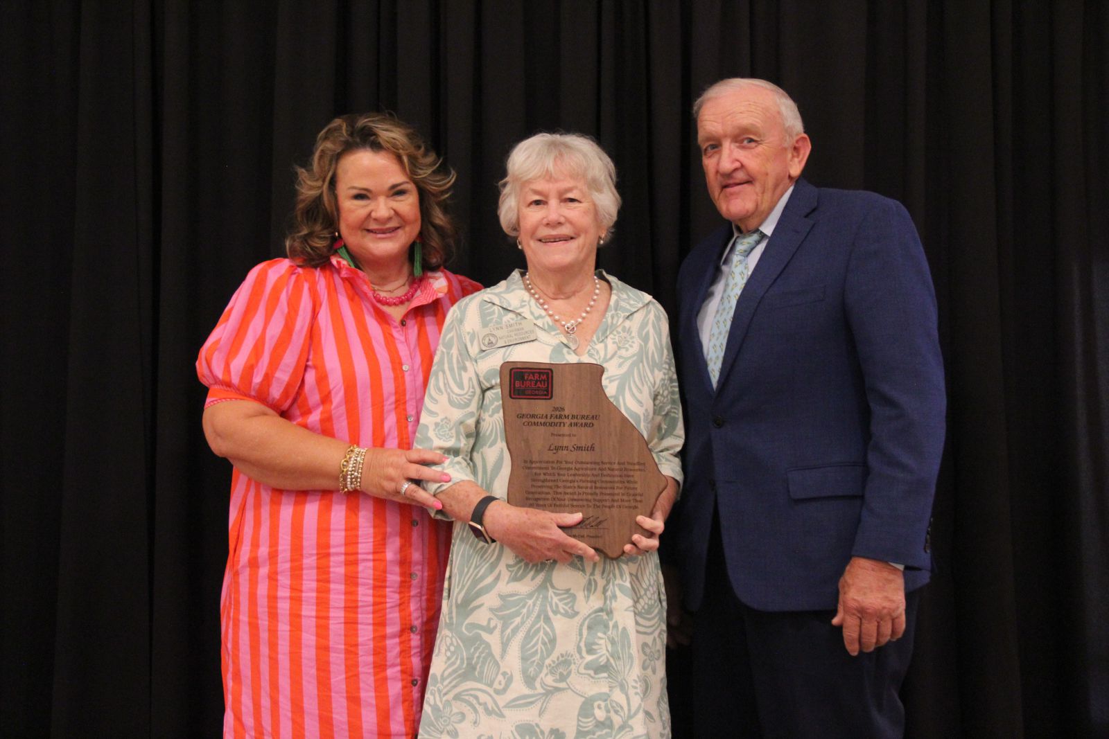 Lynn Smith between Tom and Jane McCall as they present her the Georgia Farm Bureau Commodity Award.