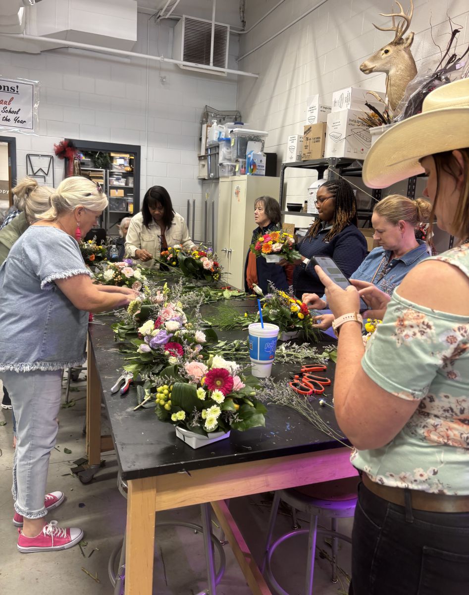 Group of seven women making flower arrangements,