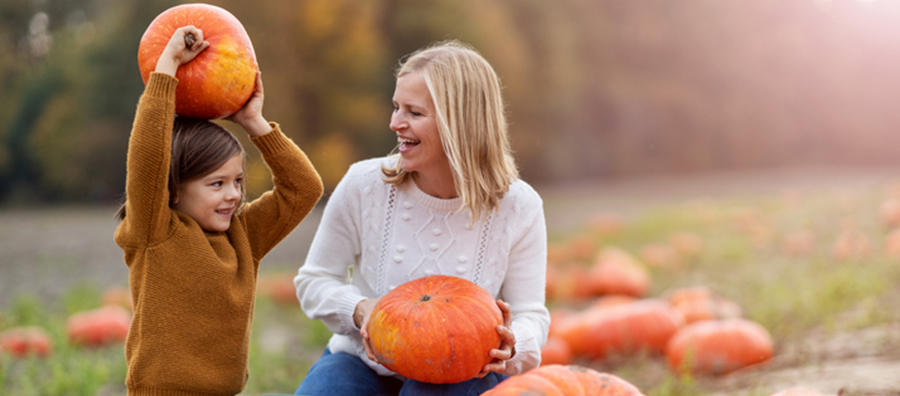 mother and daughter in pumpkin patch