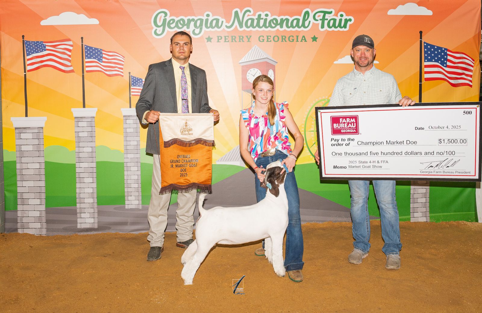 Teenage girl showing goat receives a banner from judge and a prize check from award sponsor.
