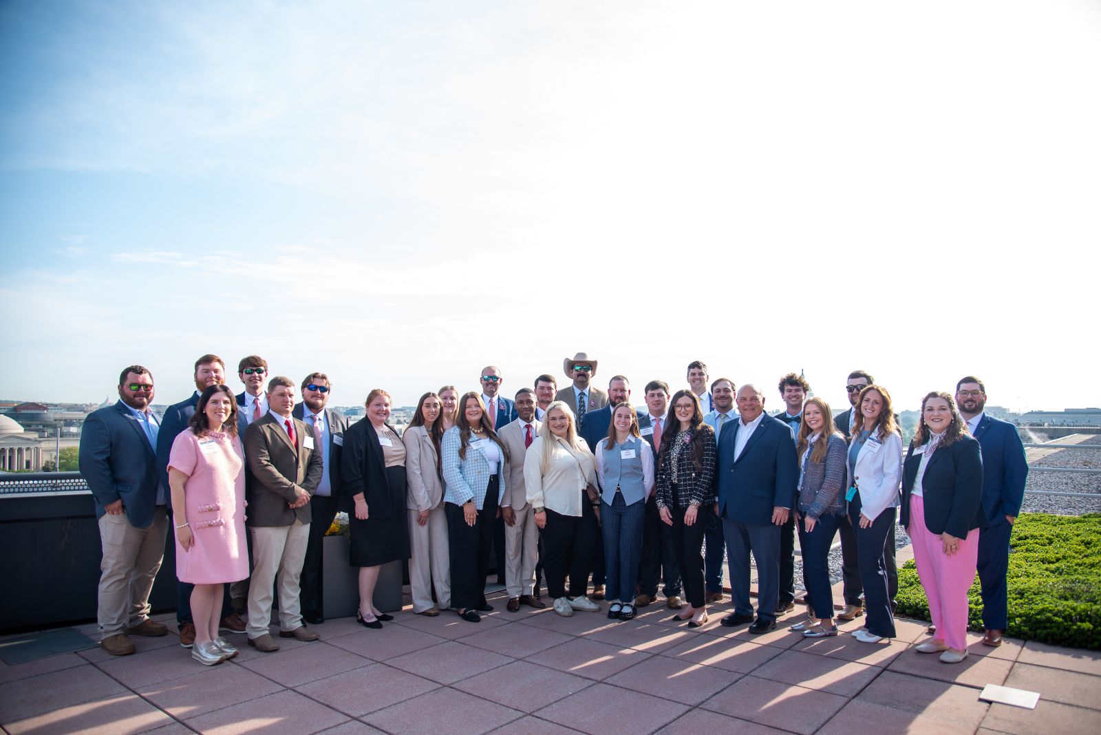 A group of 28 people in business dress on top of a building.