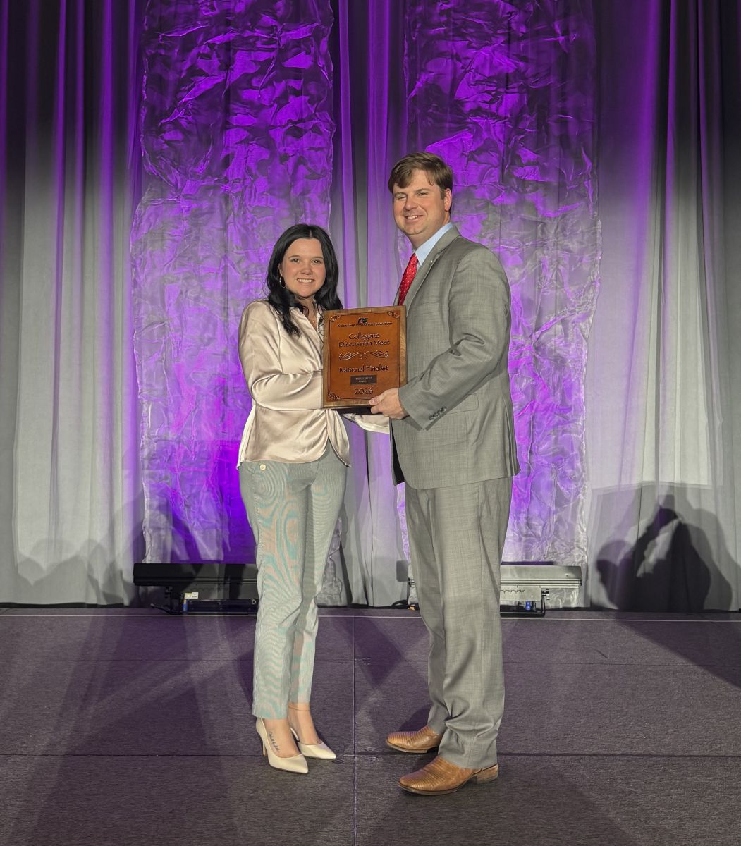 A woman receiving a plaque from a man.